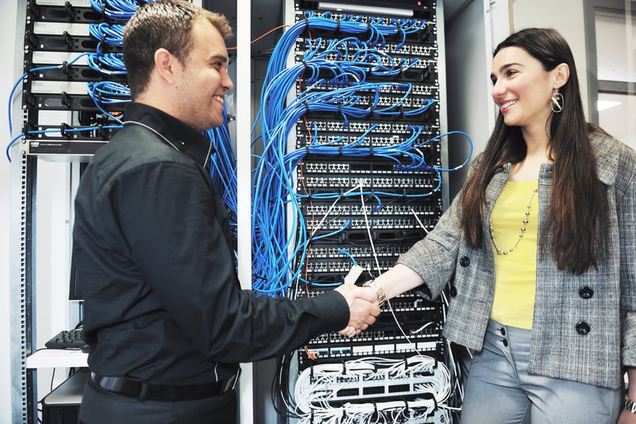 IT engineer in network server room solving problems and give help and support